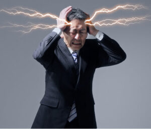 Businessman clutching head with lightning bolts, representing sudden intense pain — a visual contrast in migraine vs stroke symptoms