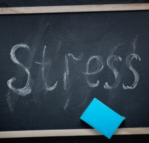 Chalkboard showing the word stress illustrating the connection between stress headaches and daily pressure