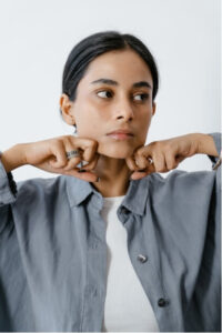Woman stretching jaw muscles, illustrating TMJ jaw pain and headaches.