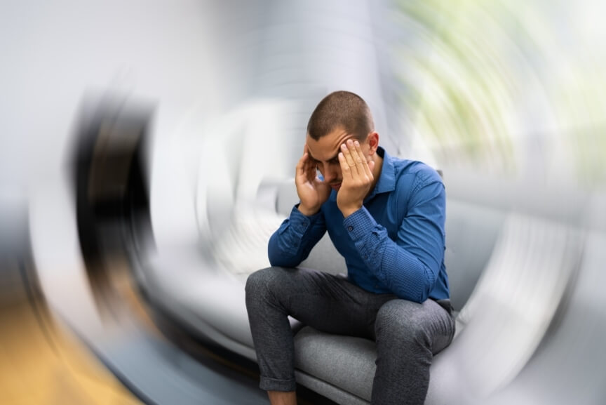 Man experiencing spinning vertigo symptoms demonstrating need for dizziness treatment